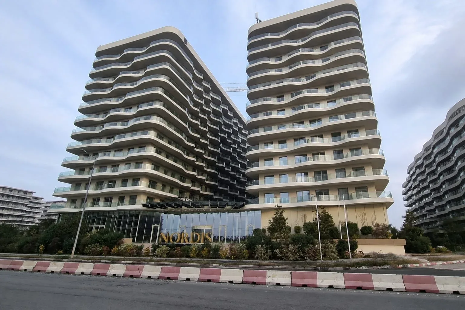 Ansamblu rezidențial cu fațadă modernă și balcoane cu design ondulat